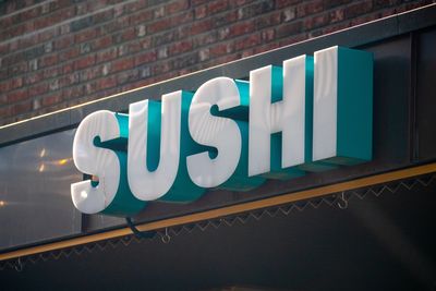 3D sign spelling 'SUSHI' on a restaurant exterior.