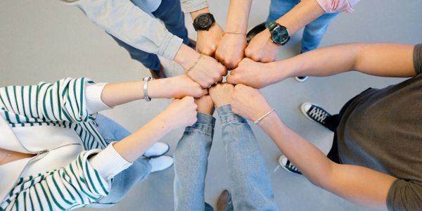 Group fist bump showing unity and teamwork.