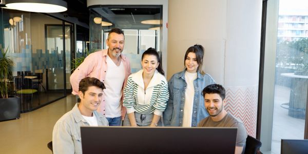 Group of coworkers watching a computer screen together.