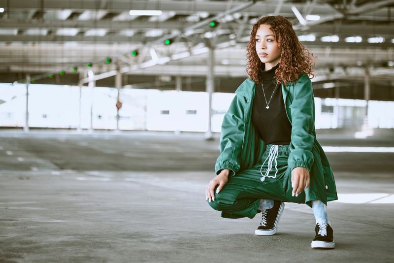 Youth, fashion and black woman with streetwear in an urban city parking lot for design, brand and hip hop lifestyle. Young woman, teenager or fashion model in designer clothes and sneakers outdoor