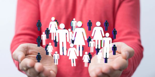 Hands holding diverse digital human icons representing community and inclusion.