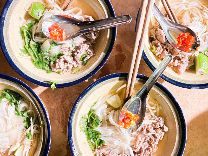 Vietnamese noodle soup with bean sprouts, coriander and beef slices as toppings