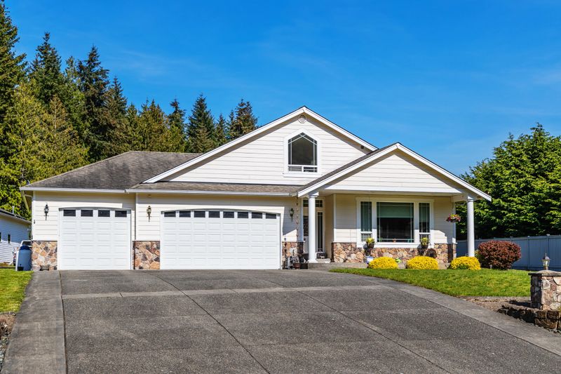 Photo of an American suburban home with a large driveway leading to a three-car garage, on a bright summer day
