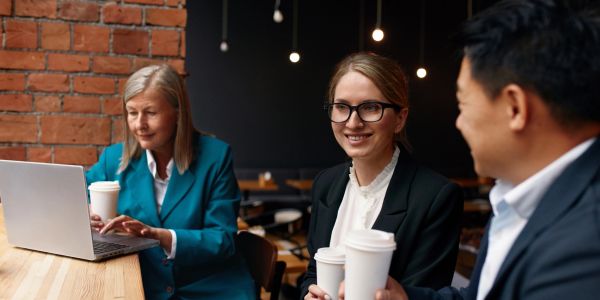 Three professionals enjoying coffee and conversation.