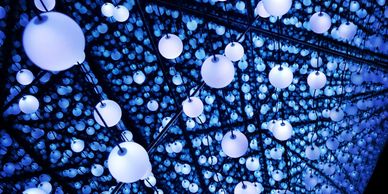 Blue glowing spherical lights suspended in a mirrored room.