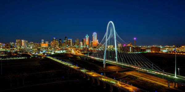 Night view of a city with a lit cable-stayed bridge.