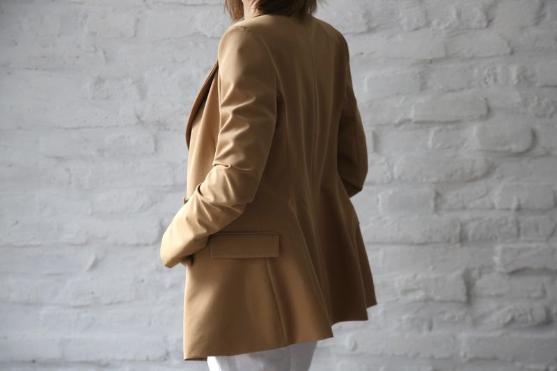 Studio portrait of young female model in beige tailored blazer