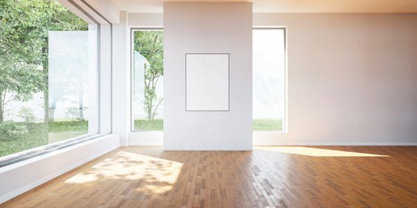 Spacious empty room with large windows and wooden floor.