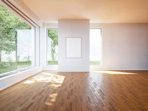 Spacious empty room with large windows and wooden floor.