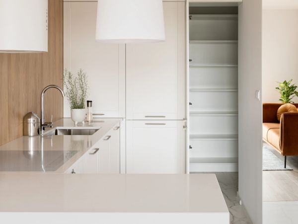 Modern kitchen with white cabinets and a large hanging light fixture.