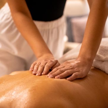 Close-up of a person receiving a back massage with oil.