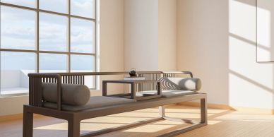 Minimalist wooden furniture by a large window with sunlight.
