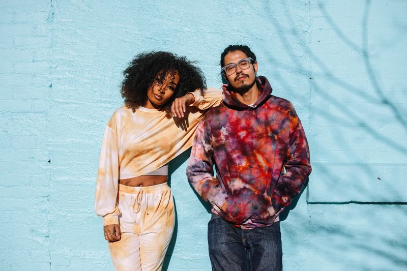 Lifestyle portrait of a fashionable, young millennials in Brooklyn, Park Slope district of NYC. They’re wearing trendy tie dye clothing, posing with an attitude.