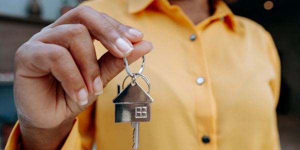 Person holding a house-shaped keychain.