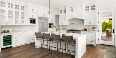 Modern white kitchen with island and four chairs.