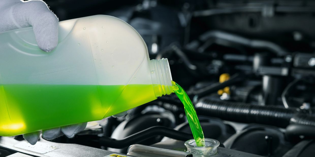 coolant being poured into a vehicles coolant tank 