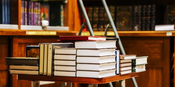 Stack of books on a table in a library.