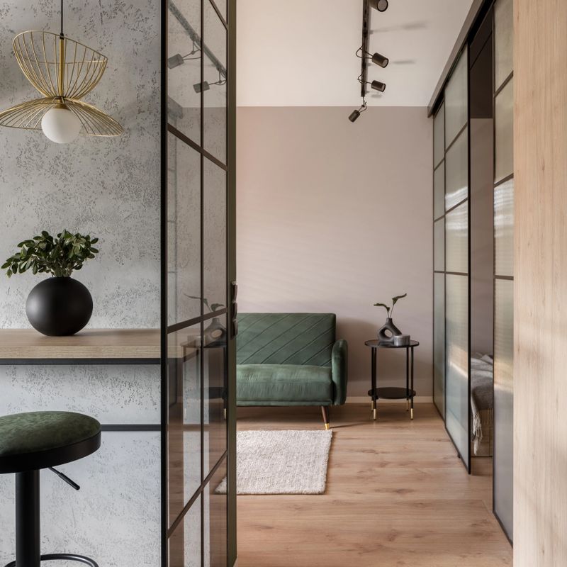 Modern home interior with reinforced glass walls in kitchen and living room, decorative concrete, new details and stylish ceiling light