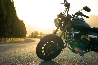 Motorcycle parked on a sunlit road.