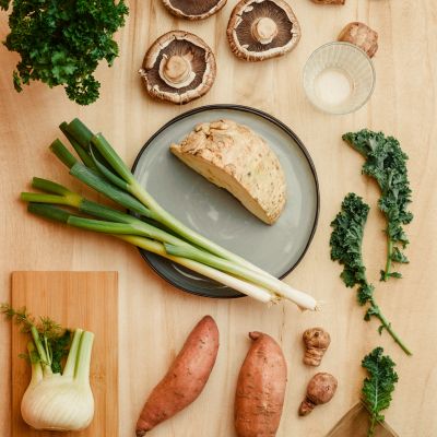 Fresh vegetables and herbs on a wooden table.