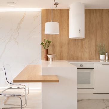 Cocina moderna con acabados en madera y blanco.