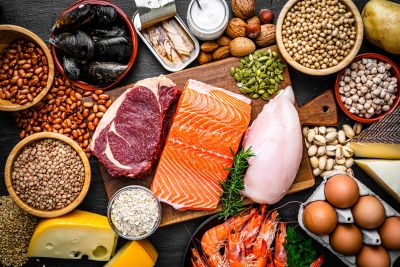 Assortment of protein-rich foods including meat, fish, eggs, and legumes.