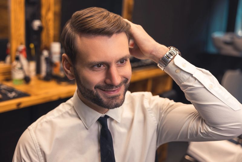 Elegant man. Good-looking confident businessman in a barbershop