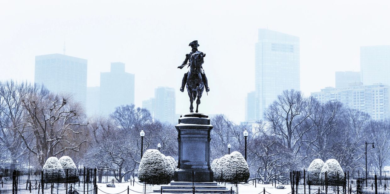 Equestrian statue in a snowy city park.