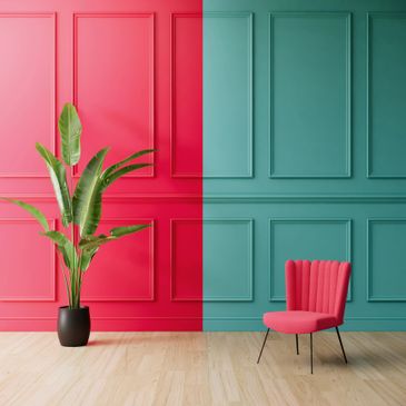 Modern interior with split red and teal walls, a green plant, and pink chair.
