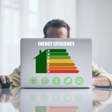 Person behind laptop with energy efficiency rating chart displayed.