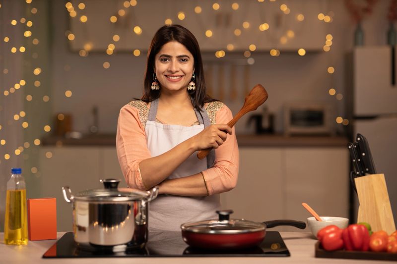Portrait of a young woman cooking food in the kitchen