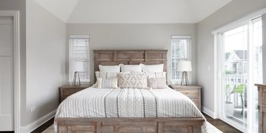 Bright bedroom with rustic wooden bed and neutral decor.
