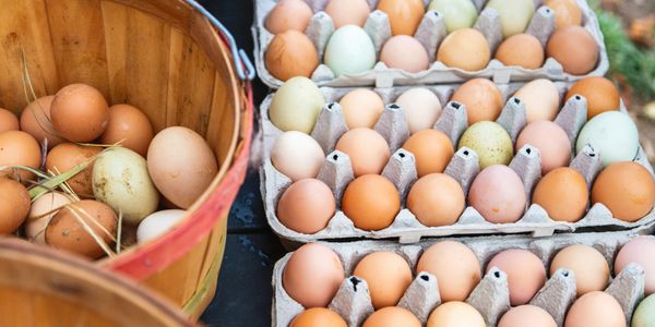 Fresh eggs in baskets and cartons at a market.