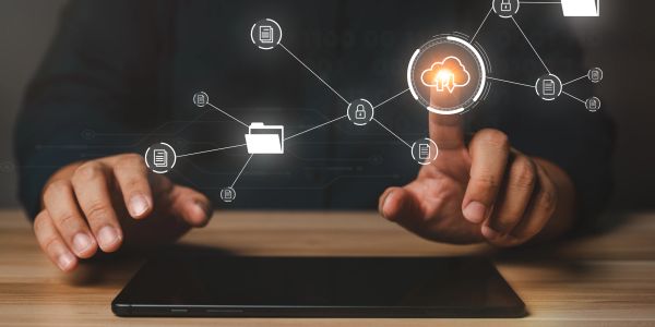 A person interacting with cloud computing icons above a tablet.