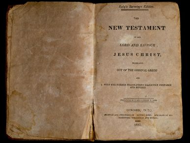 Old worn book titled New Testament of Jesus Christ.