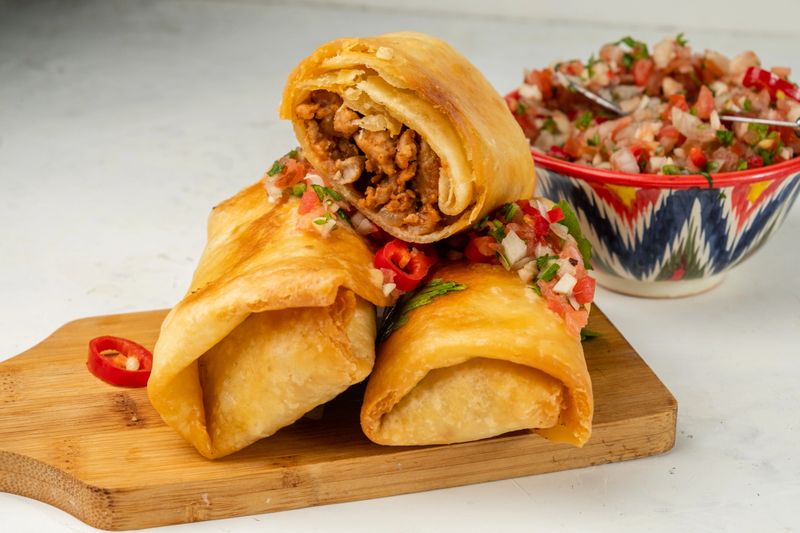 Spicy chimichanga with minced meat and beans, close-up, one in the section.