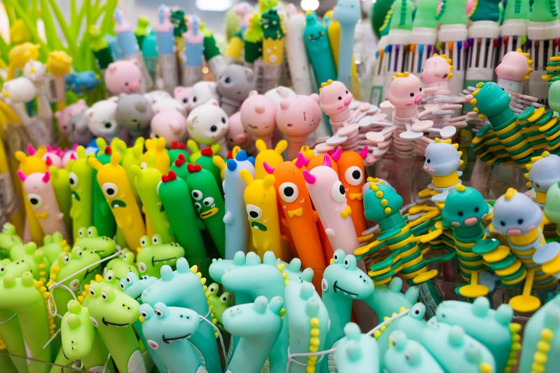Close-up of multi colored pens. Ballpoint pens in the form of small animals on a shop counter. Bright stationery goods. High quality photo