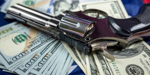 A revolver on a pile of hundred-dollar bills.