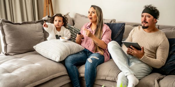 Famille regardant la télévision sur le canapé.