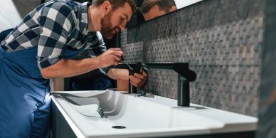 Plumber fixing a bathroom faucet.