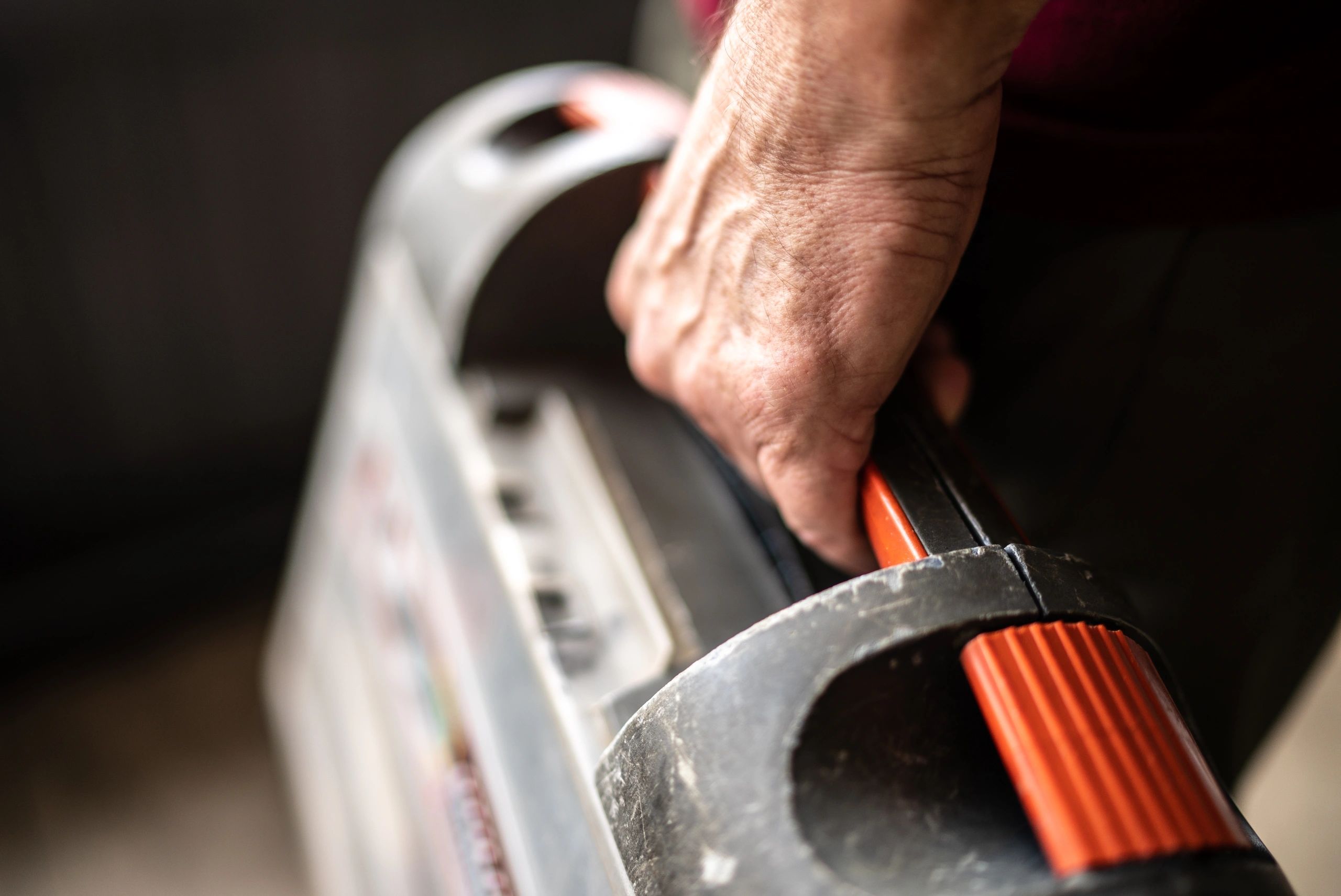 Close-up of a plumber fixing a chrome pipe with a wrench.