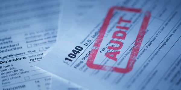 Tax form 1040 with a red AUDIT stamp.