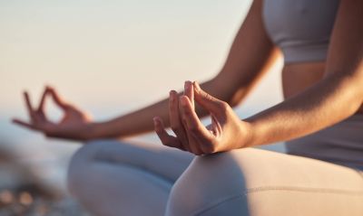 Person meditating outdoors at sunrise.