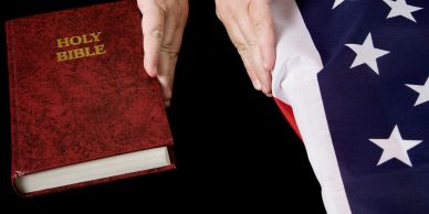 Person swearing on a Holy Bible with a US flag.