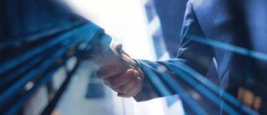 Business handshake with blue light streaks.