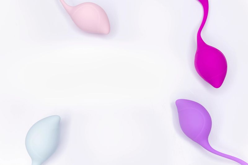 Multi-colored training kegel eggs on white background. Women's pelvic muscle training.