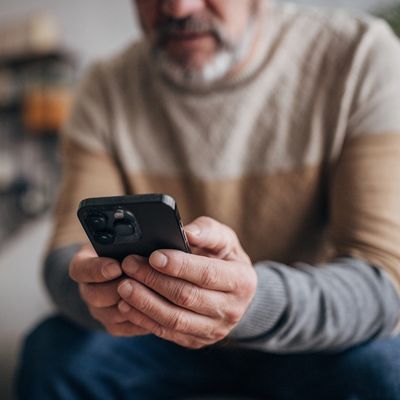 Close-up of a man using a smartphone to book a therapy session