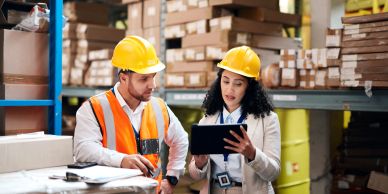 Two warehouse workers discussing tasks.