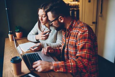 Two people working together on a laptop.
