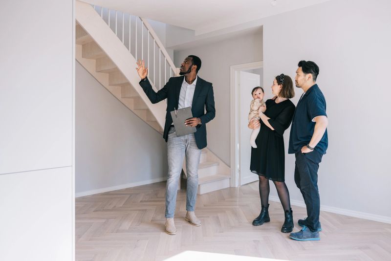 Real estate agent giving room tour for young Multi-racial family